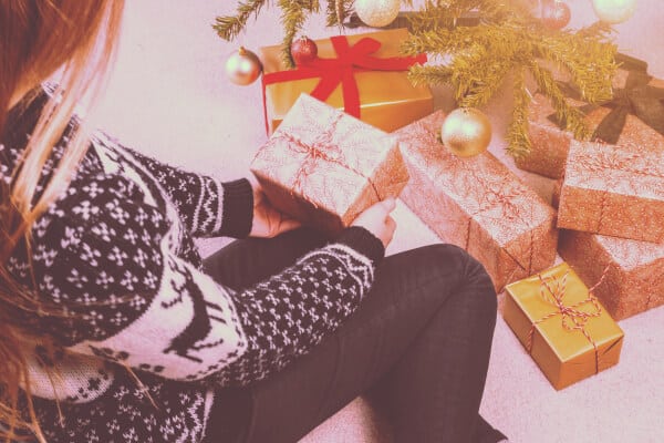 Regalo de navidad chica abriendo con jersey de navidad