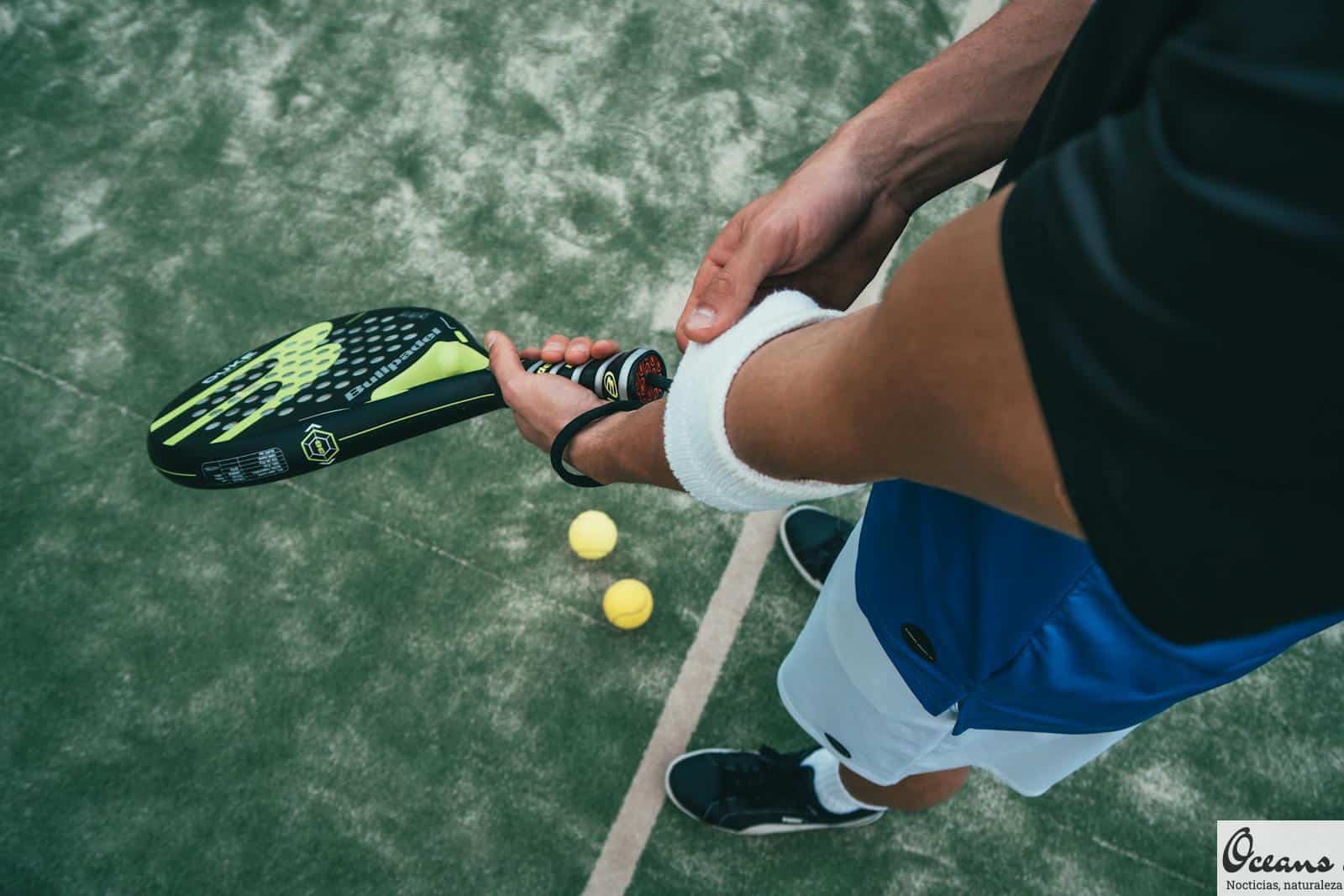 Person Holding Black and Green Tennis Racket