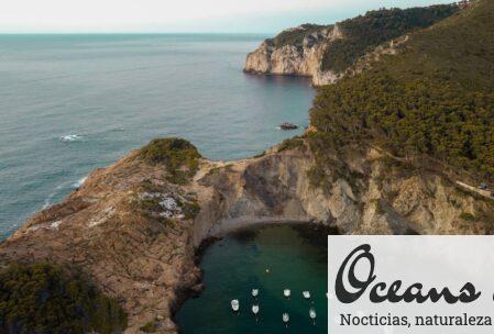 Breathtaking aerial view of Sa Tuna bay with boats and cliffs in Costa Brava, Spain.