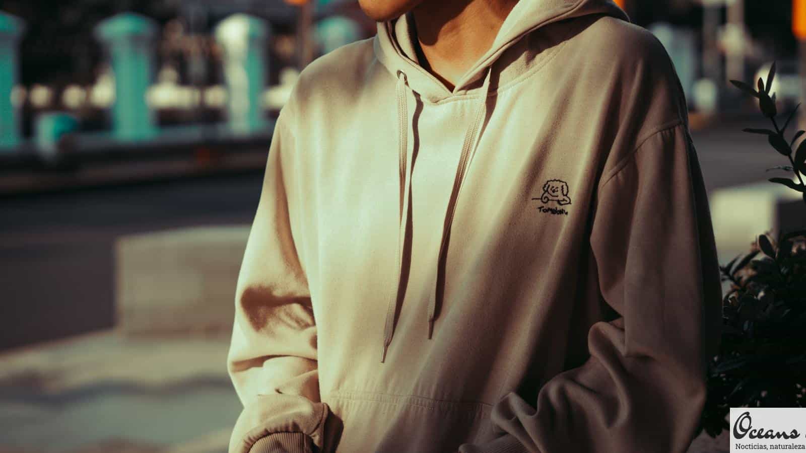 a man in a hoodie is standing on the street