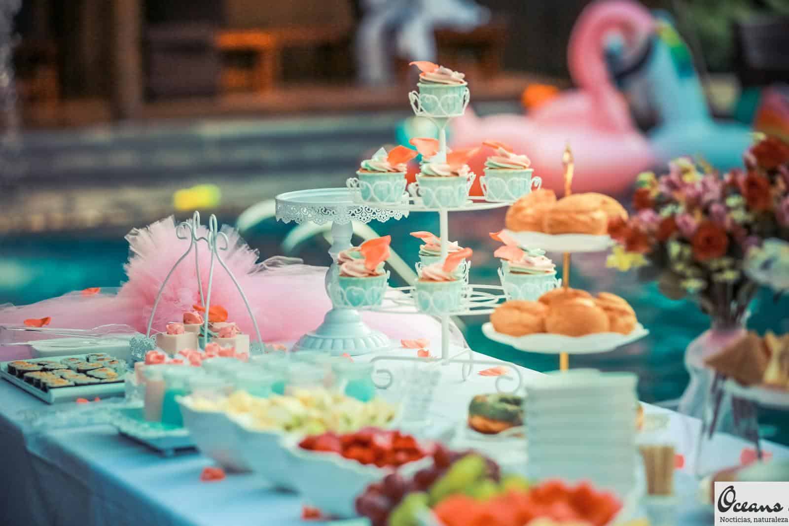 A beautifully arranged dessert table at an outdoor summer party near a pool.